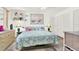 Cozy bedroom featuring a queen bed, decorative pillows, and a shelf with charming decor at 11256 Holbrook St, Spring Hill, FL 34609