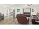 Open-concept living room with access to kitchen, featuring wood floors and leather seating at 11256 Holbrook St, Spring Hill, FL 34609