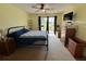 Cozy bedroom with ceiling fan, dresser, and sliding doors to a patio at 11310 Carriage Hill Dr # 4, Port Richey, FL 34668
