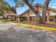 Exterior view of Timber Oaks Clubhouse featuring covered entry, landscaping, and ample parking at 11310 Carriage Hill Dr # 4, Port Richey, FL 34668