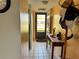 Hallway with tiled floor, coat rack and view to the front door at 11310 Carriage Hill Dr # 4, Port Richey, FL 34668