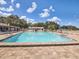 Community pool with clear blue water, surrounding lounge chairs, and a spacious deck at 11310 Carriage Hill Dr # 4, Port Richey, FL 34668
