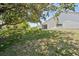 Backyard showcases a well-maintained lawn with mature trees providing ample shade and privacy at 11735 Rolling Pine Ln, Port Richey, FL 34668