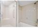 Bathroom featuring a shower and tub with white tile surround at 11735 Rolling Pine Ln, Port Richey, FL 34668