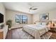 Bedroom with a ceiling fan, window, and a large bed with a patterned rug at 11735 Rolling Pine Ln, Port Richey, FL 34668