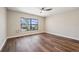 Empty bedroom features a ceiling fan, window, wood floors and baseboard trim at 11735 Rolling Pine Ln, Port Richey, FL 34668