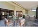A covered patio featuring a dining table, chairs, and comfortable seating presents an ideal space for outdoor gatherings at 11735 Rolling Pine Ln, Port Richey, FL 34668