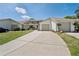 Inviting front exterior showcases a long driveway and attached garage at 11735 Rolling Pine Ln, Port Richey, FL 34668
