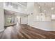 Open living area with wood floors, staircase to the second floor, and pass-through to the kitchen at 11735 Rolling Pine Ln, Port Richey, FL 34668