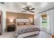 Stylish main bedroom featuring a king-sized bed, ceiling fan, and backyard views at 12201 Labrador Duck Labrador Duck Rd, Weeki Wachee, FL 34614
