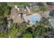 Aerial view of a pool with a surrounding patio, sun umbrellas, and lounge chairs at 12505 Dearborn Dr # C, Hudson, FL 34667