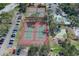 Aerial view featuring multiple tennis courts, some green and some red at 12505 Dearborn Dr # C, Hudson, FL 34667