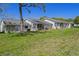 Exterior rear view featuring a green lawn and multiple screened in porches at 12505 Dearborn Dr # C, Hudson, FL 34667