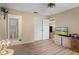 Spacious bedroom has hardwood floors, a ceiling fan, a view into the en-suite bathroom, and natural light at 12505 Dearborn Dr # C, Hudson, FL 34667
