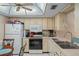 Functional kitchen with white appliances, tile floors, and ample counter space at 12505 Dearborn Dr # C, Hudson, FL 34667