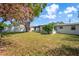 Spacious backyard with lush grass, a large shade tree, and a white fence at 12613 Social Dr, Hudson, FL 34667