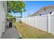 This backyard has a white fence with an air conditioning unit and trees at 12613 Social Dr, Hudson, FL 34667