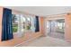 Bedroom with neutral carpet, windows, blue curtains, and a sliding glass door at 12613 Social Dr, Hudson, FL 34667