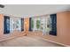 Bedroom with neutral carpet, windows, and blue curtains at 12613 Social Dr, Hudson, FL 34667