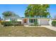 Charming single-story home with green trim, a well-manicured lawn, and mature trees at 12613 Social Dr, Hudson, FL 34667