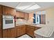 A kitchen with tiled countertops, wood cabinets, and vintage appliances at 12613 Social Dr, Hudson, FL 34667
