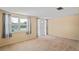 Cozy living room featuring neutral walls, carpeted floors, and a large window for natural light at 12613 Social Dr, Hudson, FL 34667