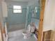 Bathroom with blue tile, standard tub and toilet needs renovation at 12801 5Th Isle, Hudson, FL 34667