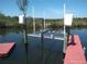 Close-up of a boat lift and dock on the canal with a tree-lined shore in the background at 12801 5Th Isle, Hudson, FL 34667