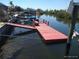View of a red wooden dock extending into the canal water with boats docked in the distance at 12801 5Th Isle, Hudson, FL 34667