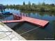 View of a red wooden dock extending into the canal water with lush greenery on the banks at 12801 5Th Isle, Hudson, FL 34667