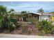 Cozy brick home with a well-manicured lawn, mature trees, and an inviting front exterior at 12801 5Th Isle, Hudson, FL 34667