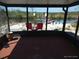 Enclosed porch with two red chairs overlooking a canal with a dock and boat lift at 12801 5Th Isle, Hudson, FL 34667