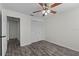 A neutral bedroom featuring gray wood floors, ceiling fan, and closet for storage solutions at 152 Chelsea Ct, Dunedin, FL 34698