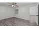 Bedroom offers neutral paint, ceiling fan, gray wood floors and a large window at 152 Chelsea Ct, Dunedin, FL 34698