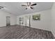 Spacious living room with wood floors, ceiling fan, and natural light from the sliding glass door at 152 Chelsea Ct, Dunedin, FL 34698