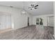 Bright living room boasts wood floors, ceiling fan, sliding glass door and stylish light fixture at 152 Chelsea Ct, Dunedin, FL 34698