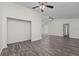 Large open living room featuring gray wood floors, ceiling fans and bright white paint at 152 Chelsea Ct, Dunedin, FL 34698