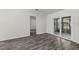 Bright living room showcases a slider to the lanai and gray wood floors at 152 Chelsea Ct, Dunedin, FL 34698