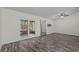 Spacious living room area with hardwood floors, ceiling fans, and sliding glass doors to the sunroom at 152 Chelsea Ct, Dunedin, FL 34698