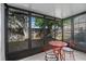 Enclosed porch featuring tile flooring and table with two chairs for outdoor relaxation at 152 Chelsea Ct, Dunedin, FL 34698