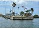 Scenic waterfront view with a dock, palm trees, and clear skies at 152 Chelsea Ct, Dunedin, FL 34698