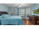 Comfortable bedroom with hardwood floors, ceiling fan, and access to the sunroom at 2309 Terrace View Ln, Spring Hill, FL 34606