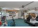 Well-organized garage with storage cabinets, a golf cart, bicycles, and blue carpet at 2309 Terrace View Ln, Spring Hill, FL 34606