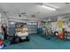Spacious garage featuring a golf cart, bikes, storage shelves, and blue carpet at 2309 Terrace View Ln, Spring Hill, FL 34606
