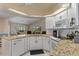 Kitchen features a breakfast bar, white cabinets, granite countertops, and stainless steel appliances at 2309 Terrace View Ln, Spring Hill, FL 34606