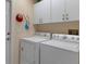 Neat laundry area with washer, dryer, and overhead cabinets at 2309 Terrace View Ln, Spring Hill, FL 34606