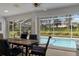 Covered patio with a dining table and chairs overlooking a screened pool and backyard at 2309 Terrace View Ln, Spring Hill, FL 34606
