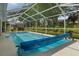 Sparkling screened pool with a pool cover and serene backyard views at 2309 Terrace View Ln, Spring Hill, FL 34606