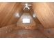 Attic space features wood paneling, a ceiling fan, and a window, offering potential for storage or conversion at 23310 Cascade Pl, Land O Lakes, FL 34639