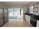 Modern kitchen with stainless steel appliances, granite countertops, and access to screened lanai at 23310 Cascade Pl, Land O Lakes, FL 34639